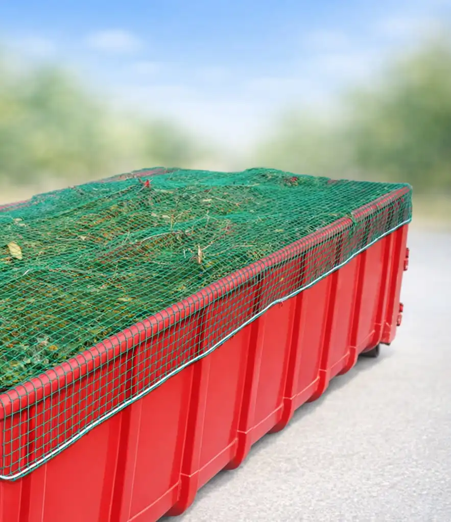 Großer roter Container mit Gartenabfällen wie Rasenschnitt, abgedeckt durch ein grünes knotenloses Netz aus Polypropylen  mit einer ringsumlaufenden Gummileine zur Ladungssicherung. 