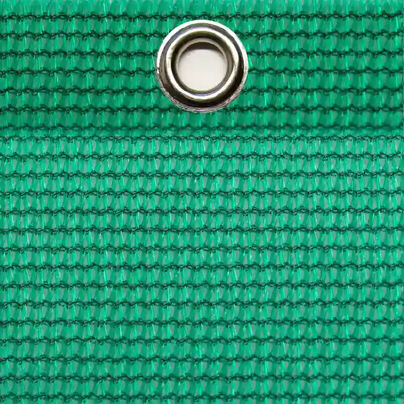 Nahaufnahme einer grünen Abdeckplane mit einer silbernen Metallöse am oberen Rand
