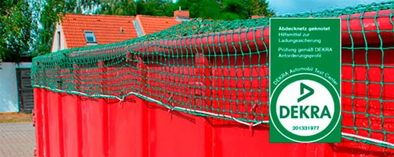 Ein Abdecknetz an einem roten Container mit einer umlaufender Grummileine. Dekra Zeichen im Vordergrund